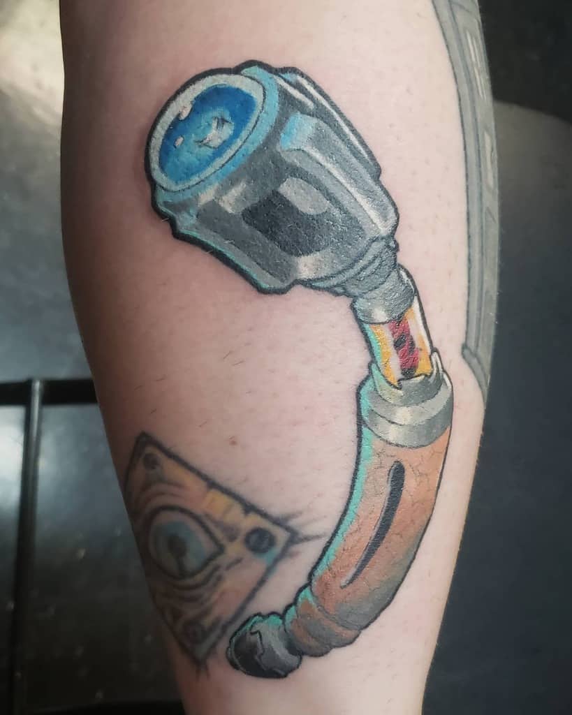Realistic tattoo of a detailed Sonic Screwdriver from Doctor Who, featuring intricate shading and vibrant colors