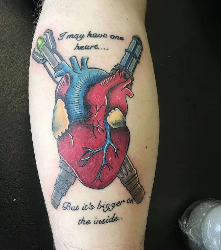 Creative Doctor Who tattoo featuring a human heart held by two Sonic Screwdrivers, with the quote 'I may have one heart... But it's bigger on the inside'