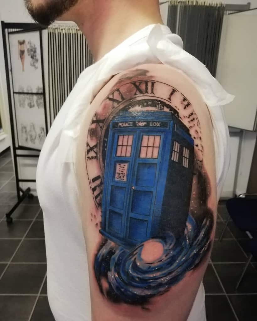 Doctor Who tattoo featuring the TARDIS emerging from a swirling time vortex, framed by a Roman numeral clock