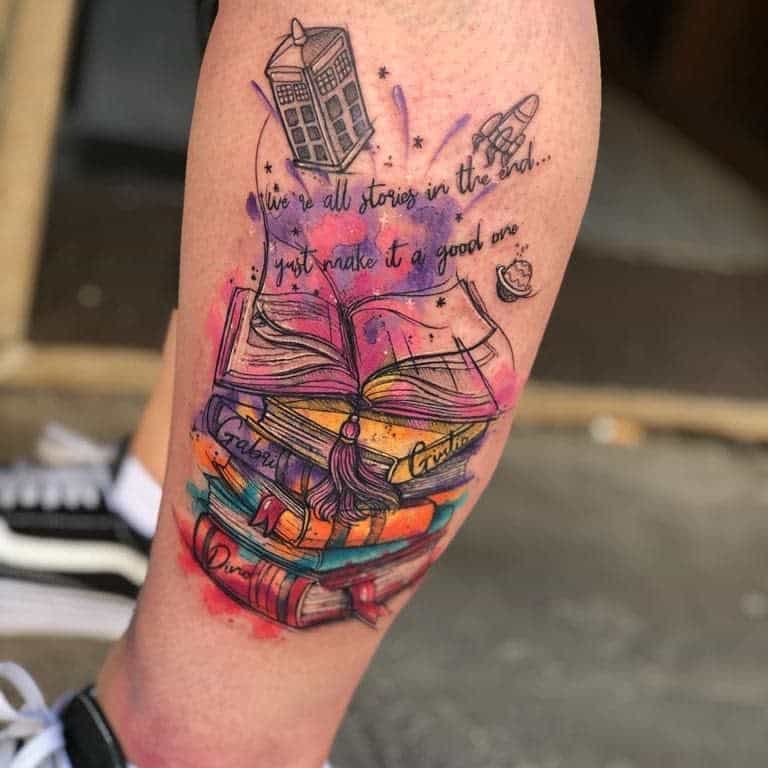 Doctor Who tattoo featuring a watercolor-style stack of books with an open book, the TARDIS, a rocket, and the quote 'We're all stories in the end... just make it a good one.'