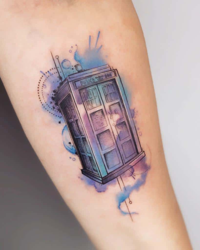 Doctor Who tattoo featuring the TARDIS with a soft watercolor effect in shades of blue and purple, accented by geometric and abstract details