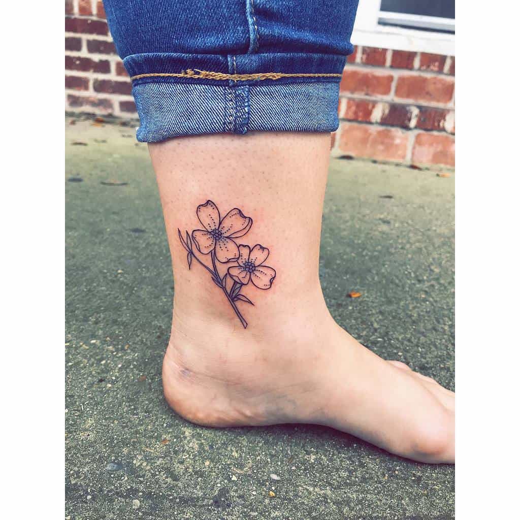 Ankle tattoo of two delicate dogwood flowers with leaves