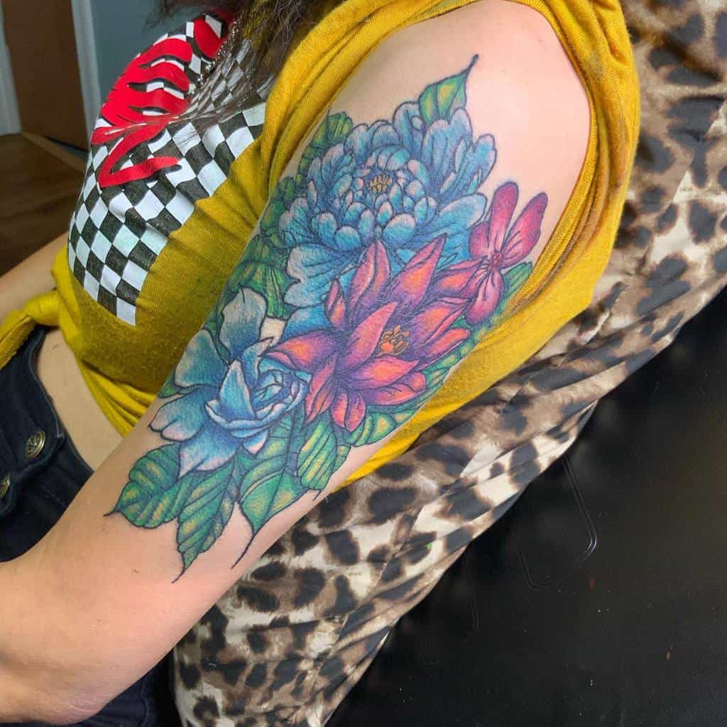 A vibrant floral tattoo sleeve featuring dogwood blossoms adorns a person's arm