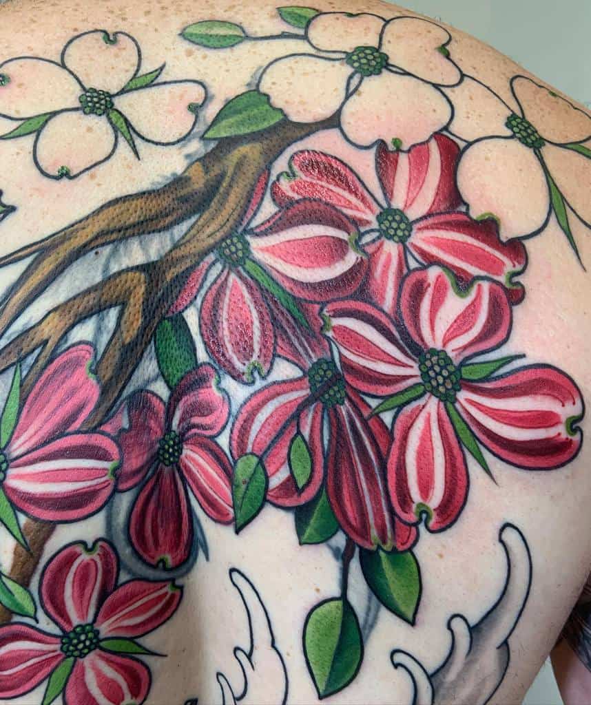 Back tattoo of pink and white dogwood flowers with green leaves and brown branches