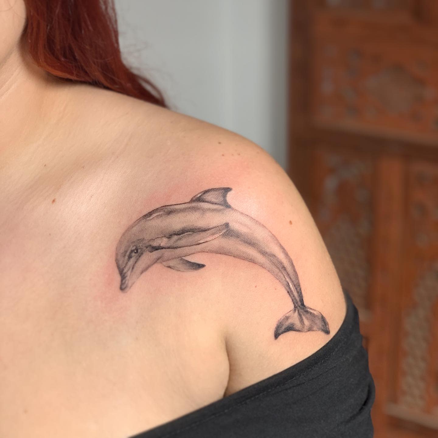 A dolphin tattooed on a shoulder