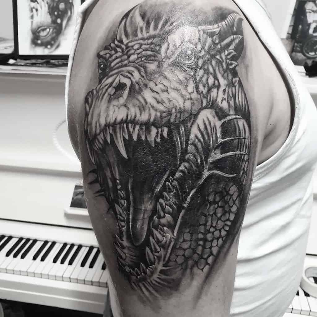 A detailed dragon head tattoo on an upper arm