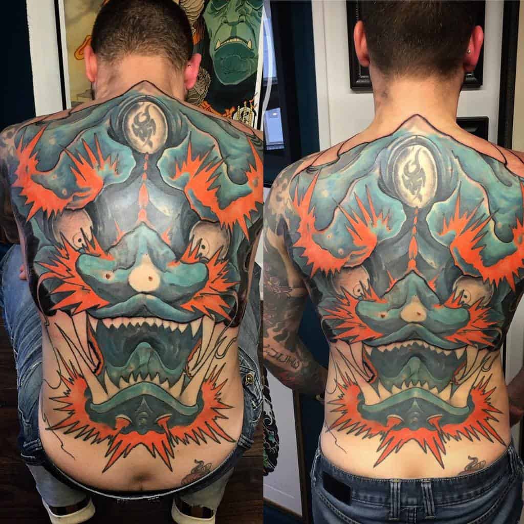 Back tattoo with a colorful, fierce dragon head featuring blue, orange, and black details