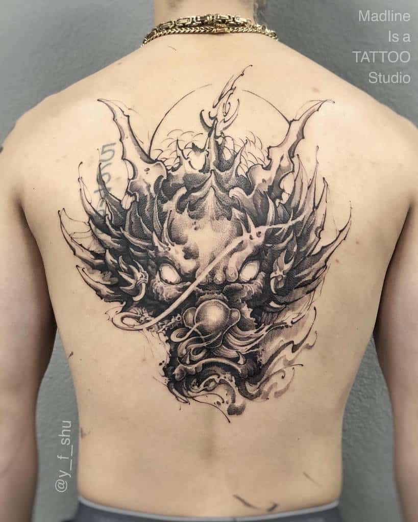 A man with a detailed dragon head tattoo that extends from his back to head