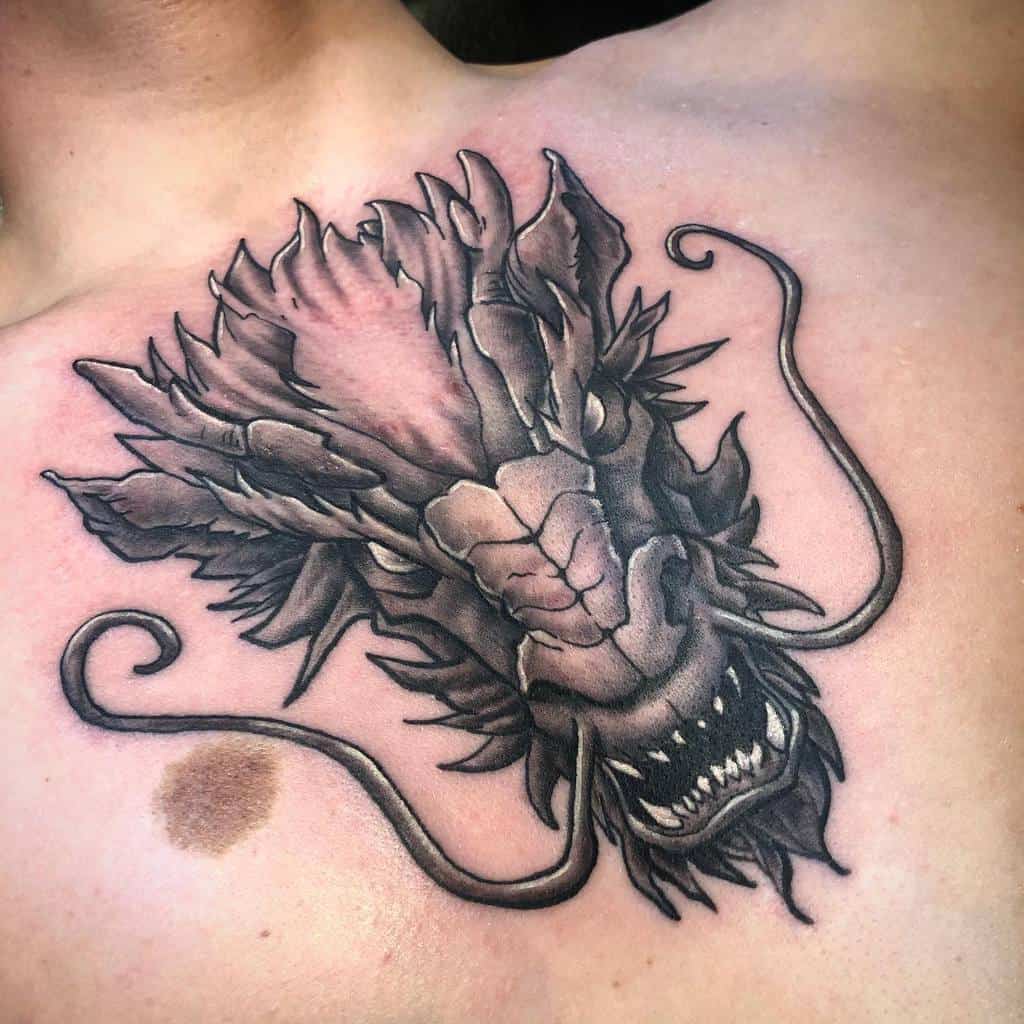 A chest tattoo featuring the roaring head of a dragon with intricate details and exquisite shading