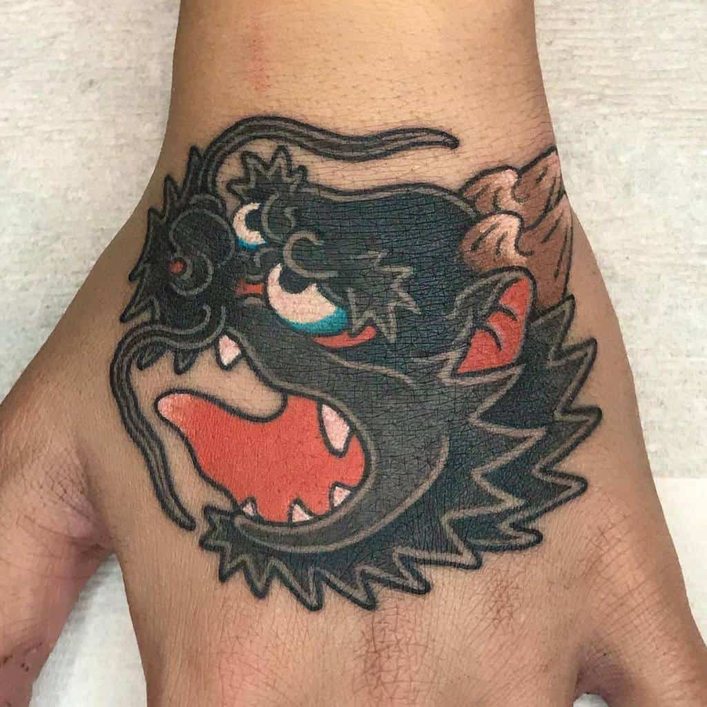 A vibrant tattoo of a stylized dragon wraps around the hand, with its head artfully detailed in striking colors