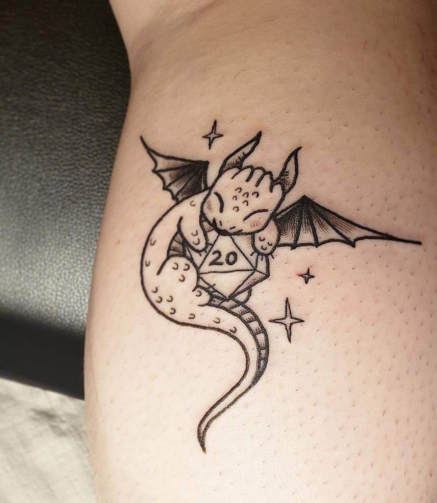 Minimalist black ink tattoo of a tiny dragon hugging a D20 dice with sparkles around it