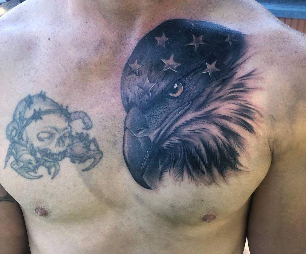 Chest tattoo of a detailed eagle head with stars