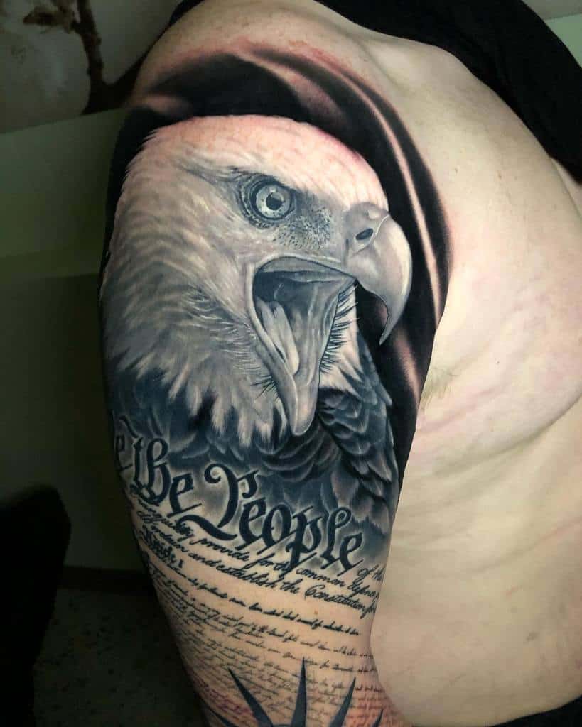Realistic eagle tattoo on an upper arm with script resembling a historical document below the eagle