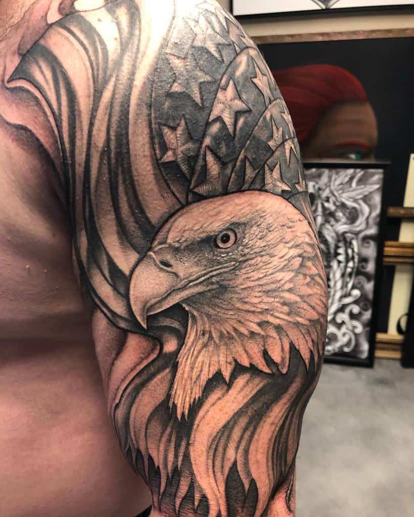 Tattoo of an eagle head with an American flag design on the upper arm