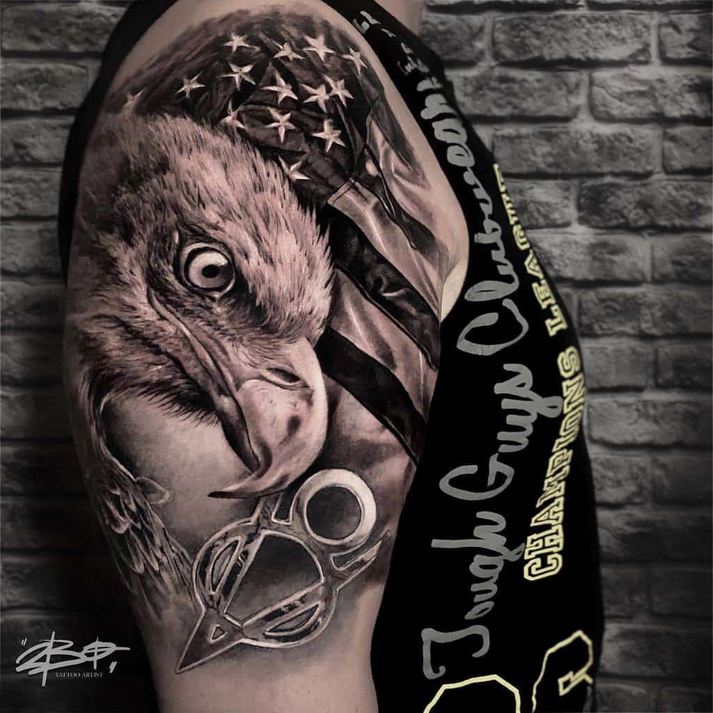 Arm tattoo of an eagle head and American flag, sleeveless shirt with text