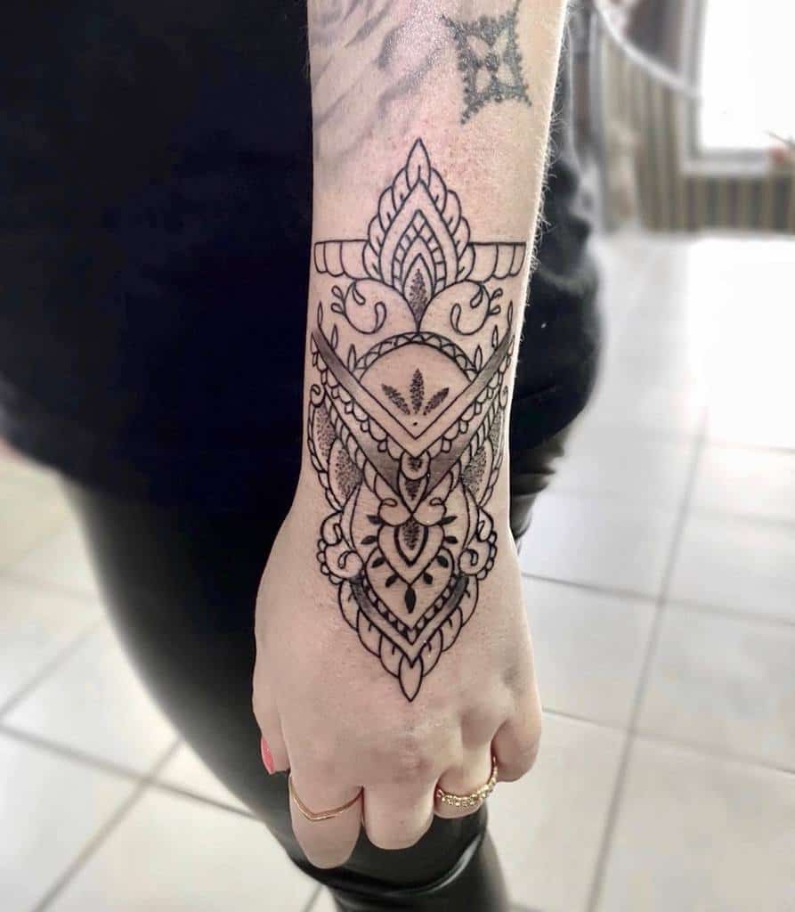 Elegant black ink tattoo with intricate mandala and geometric patterns