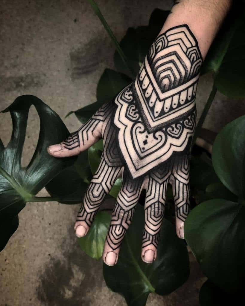 Bold blackwork geometric tattoo featuring intricate symmetrical patterns and strong contrast.