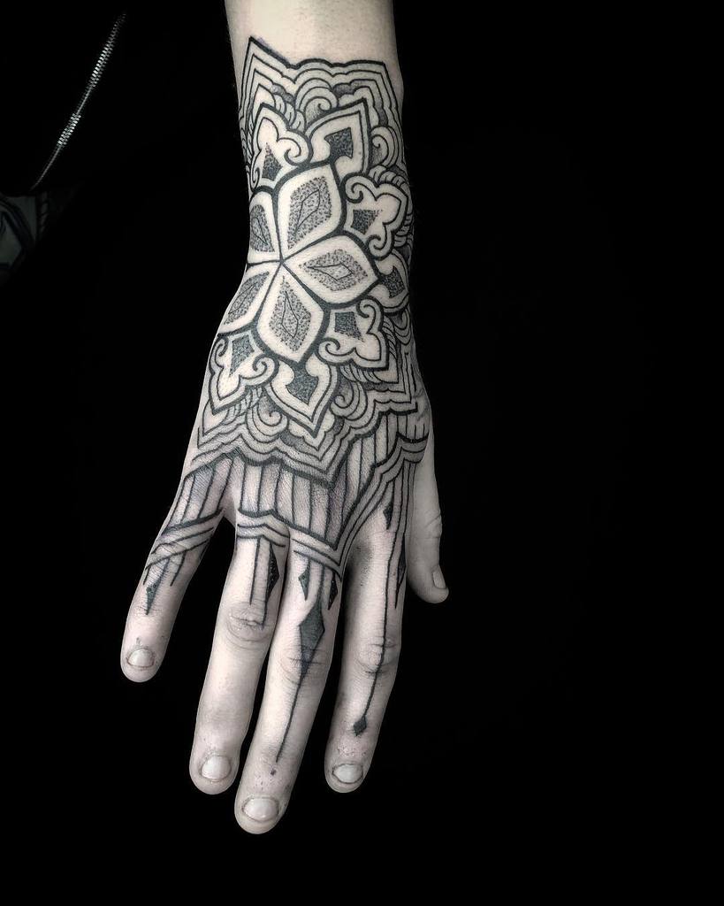Blackwork tattoo with a mandala-inspired floral design extending into geometric patterns.