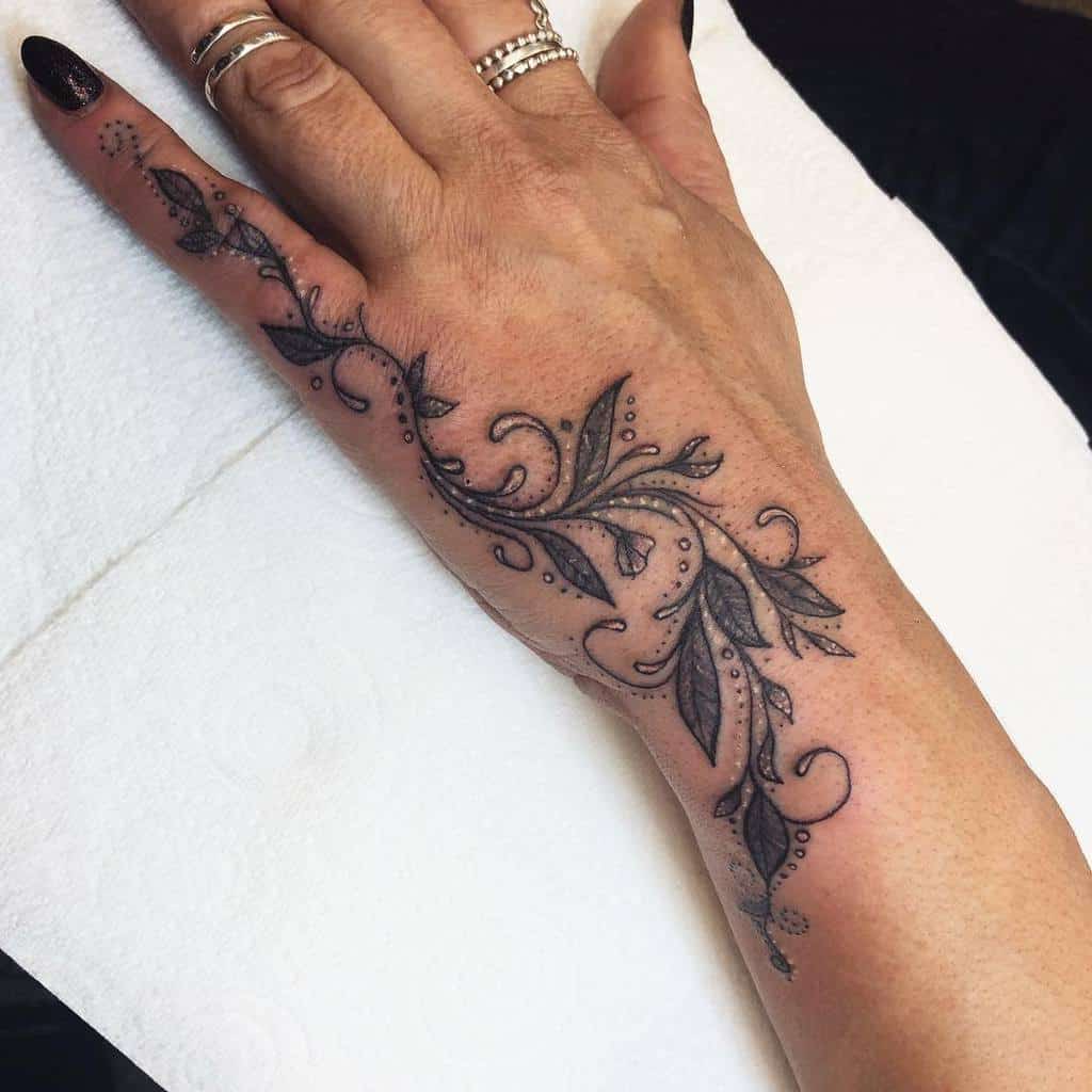 Elegant floral tattoo with delicate vine-like patterns with white and black dots
