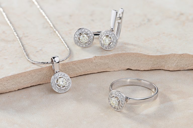 Elegant jewelry set of white gold ring, necklace and earrings with diamonds. Silver jewellery set with gemstones. Product still life concept