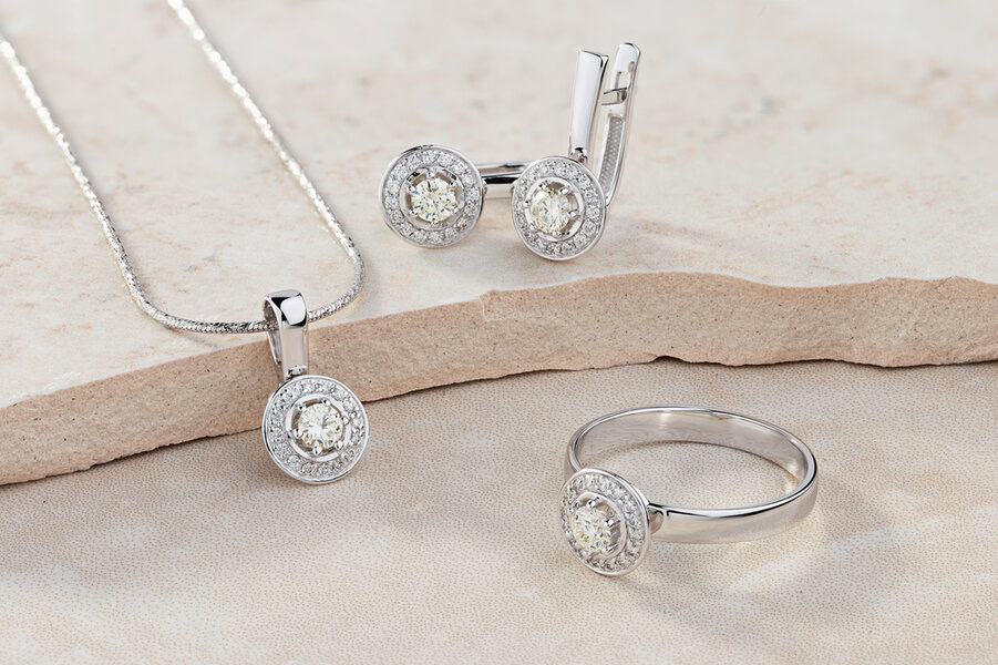 Elegant jewelry set of white gold ring, necklace and earrings with diamonds. Silver jewellery set with gemstones. Product still life concept