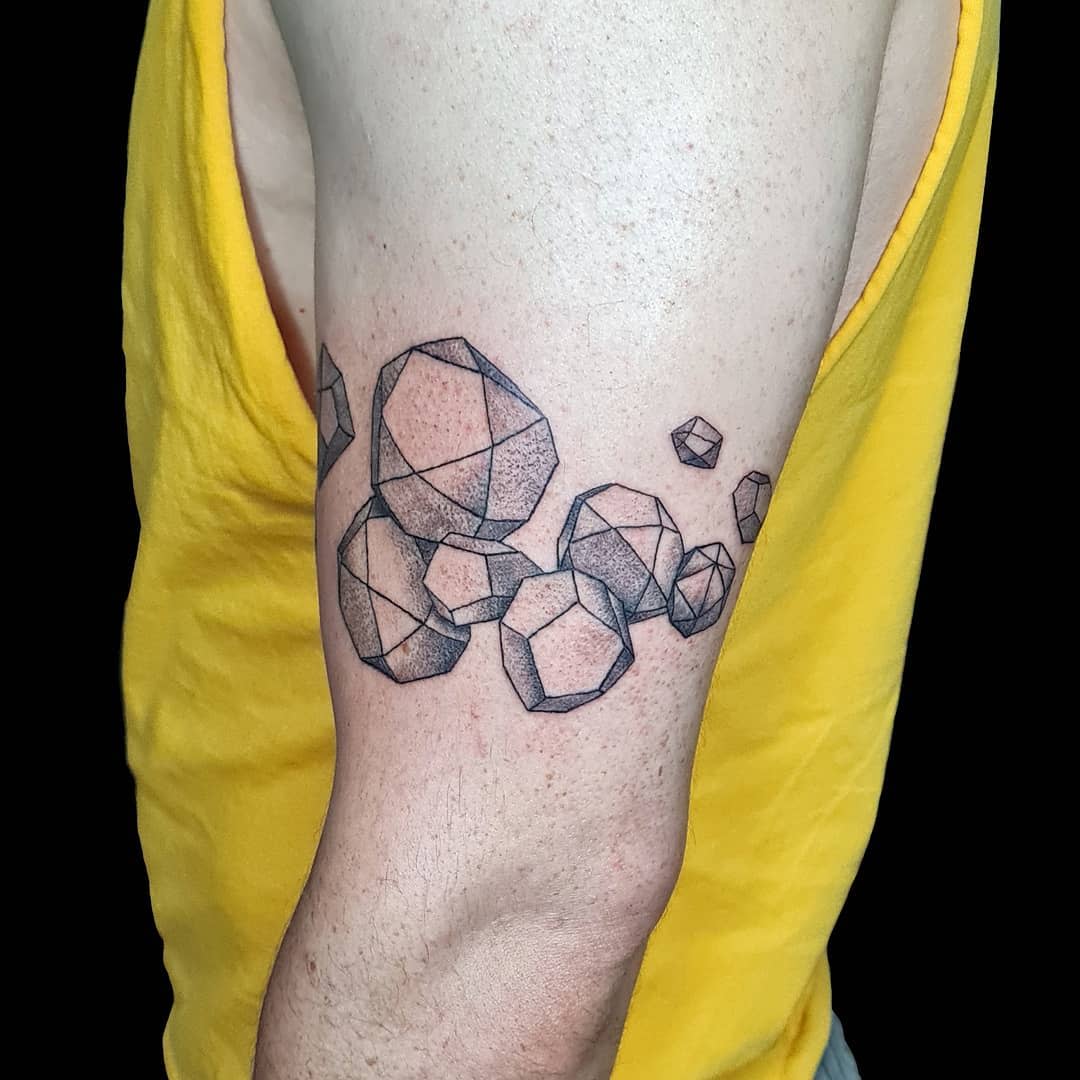Geometric polygonal tattoo on an upper arm