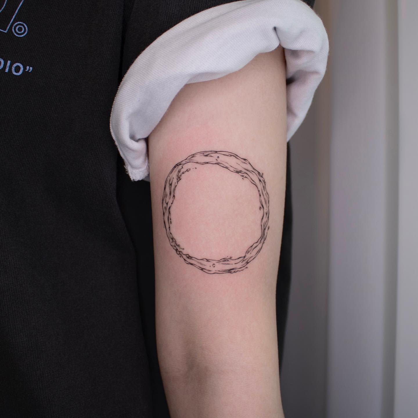 Circular branch tattoo on the upper arm