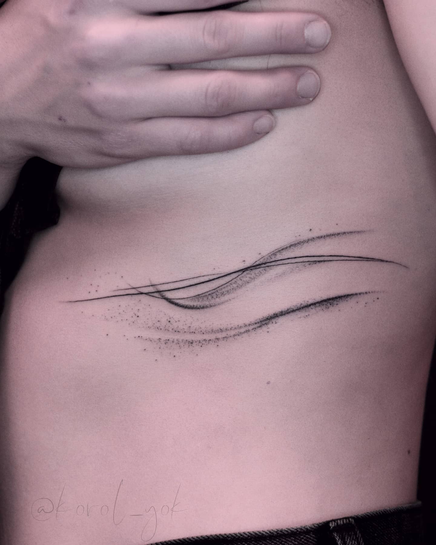 Abstract wave tattoo design on a ribcage
