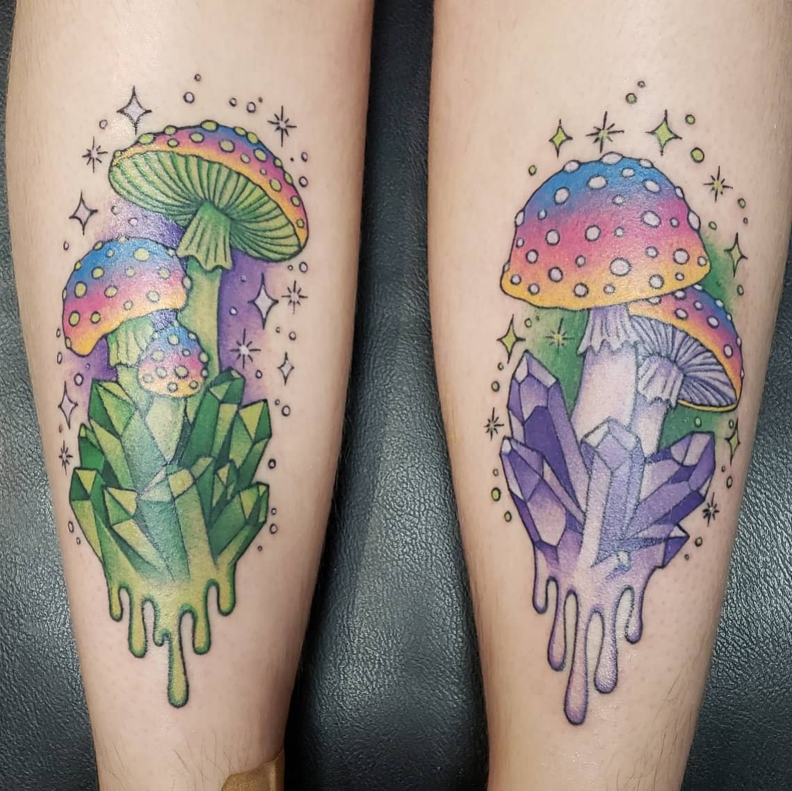 Colorful tattoos of mushrooms and crystals on the side of two calves with sparkles