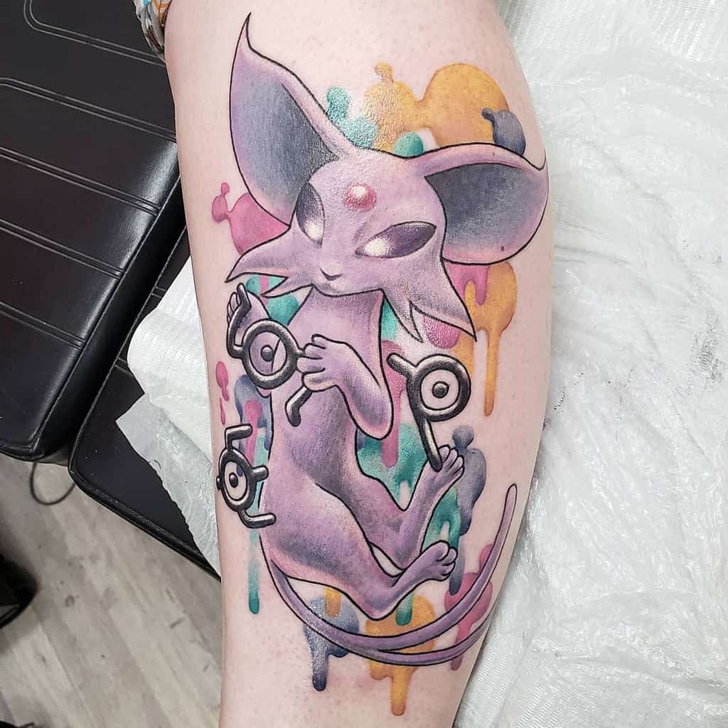 Mystical Espeon tattoo with glowing eyes, surrounded by Unown symbols and a dripping watercolor background in bold hues