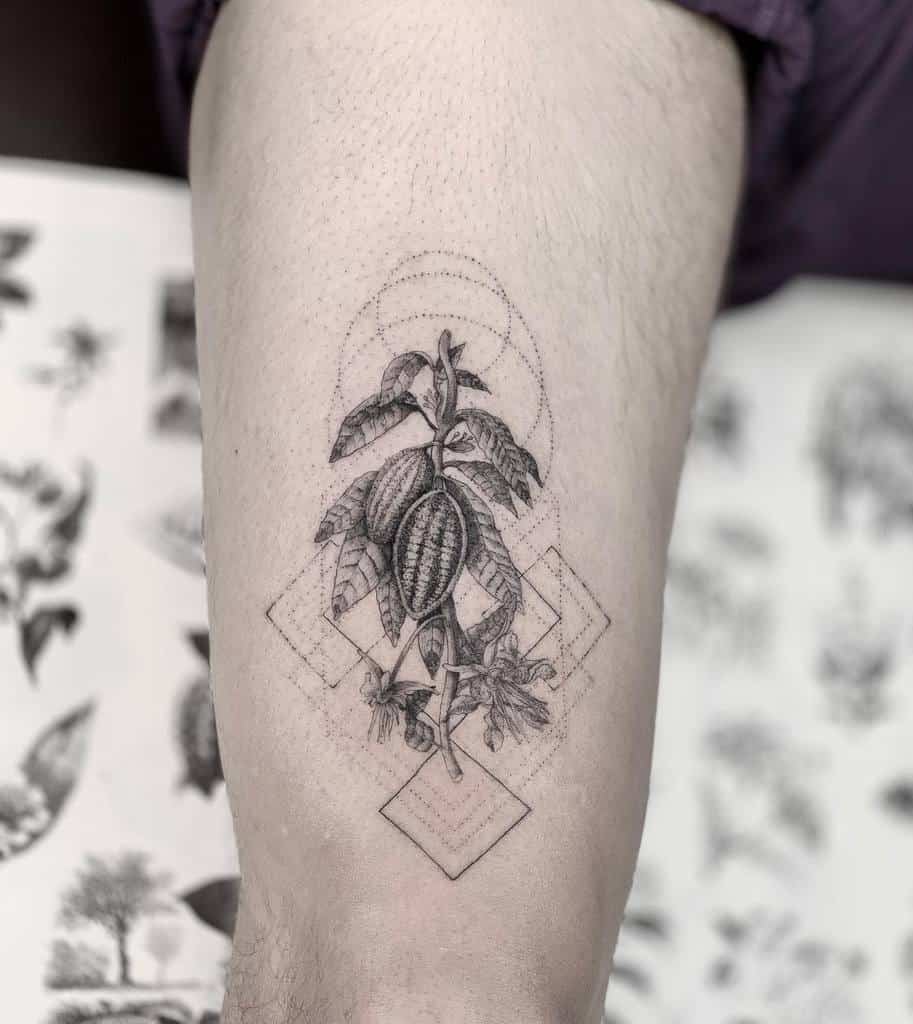 Tattoo of a geometric design with leaves and a cocoa pod on an arm