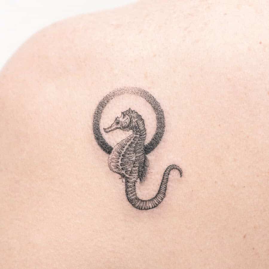 Small seahorse tattoo with circular design on person's skin, created using single needle technique