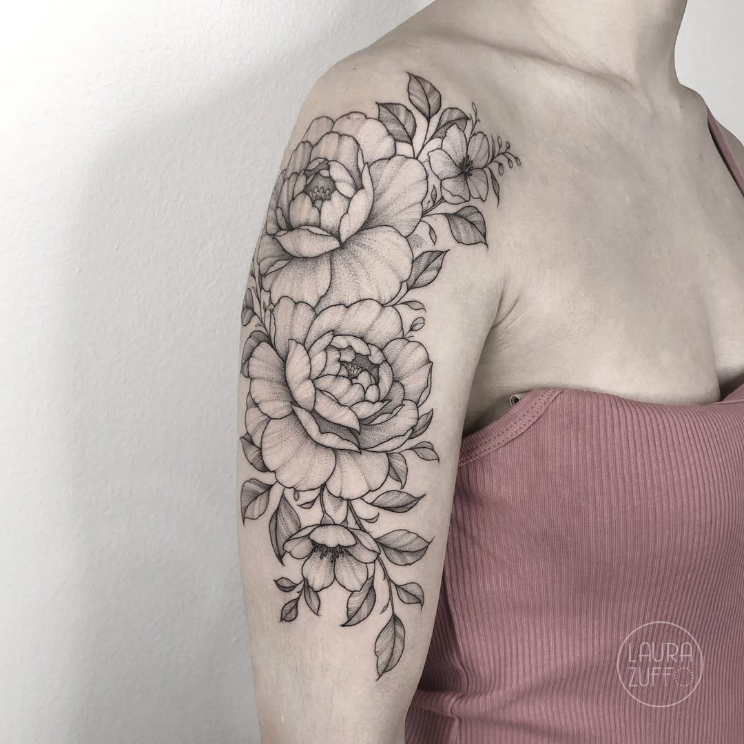 Tattoo with detailed floral design on the right upper arm