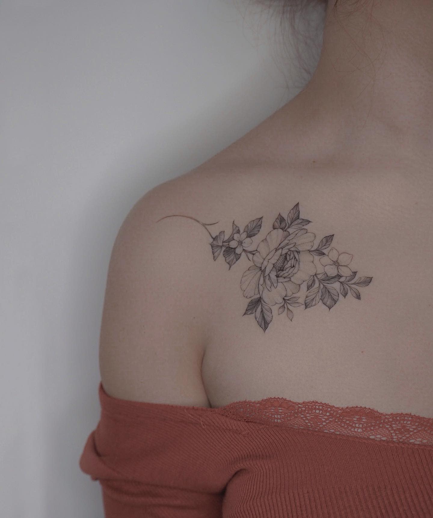 A woman with a floral tattoo on her shoulder