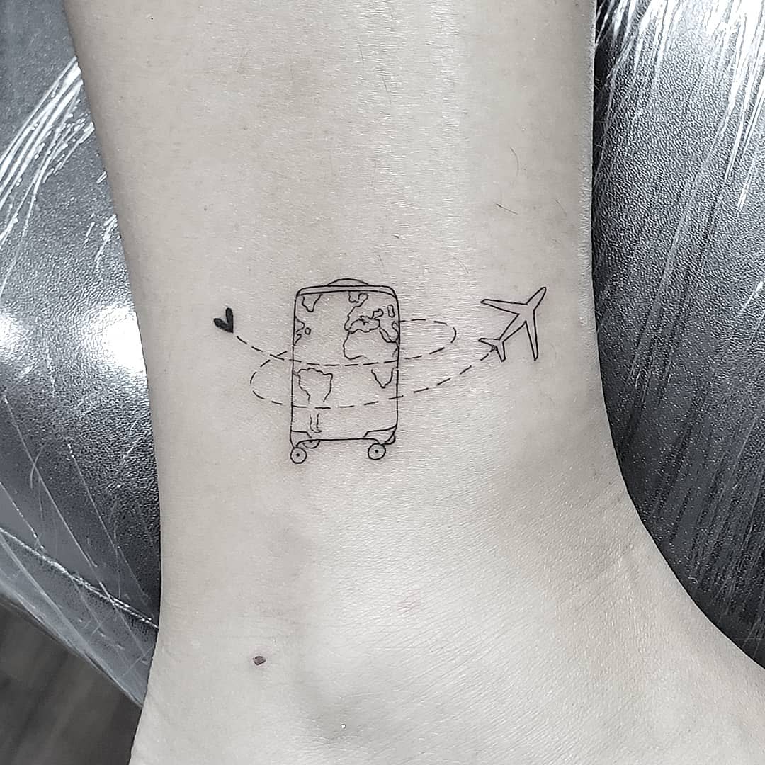 A suitcase with a world map and an airplane circling it near an ankle, symbolizing travel or adventures
