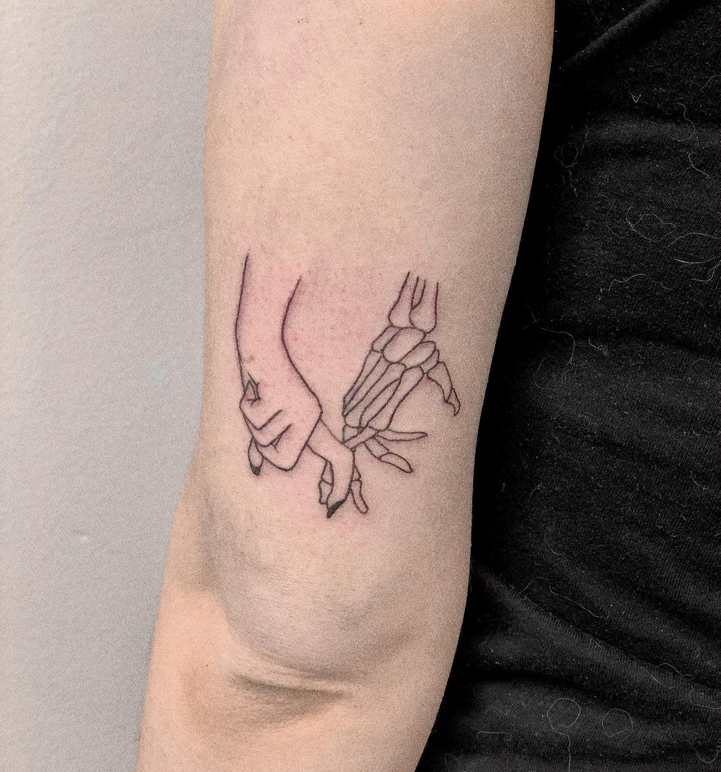 A human hand clasping a skeletal hand