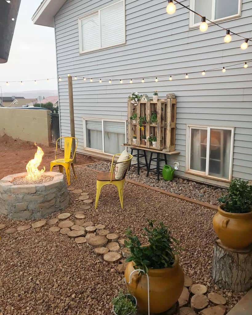 stone fire pit yellow chairs wood pallet planter hanging lights