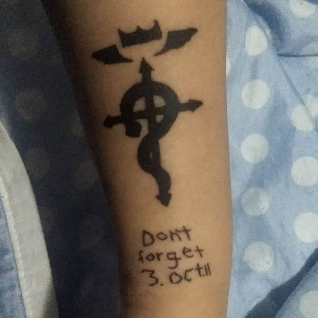 Fullmetal Alchemist tattoo featuring the Flamel symbol above the handwritten phrase "Don't forget 3. Oct. 11," referencing a key date