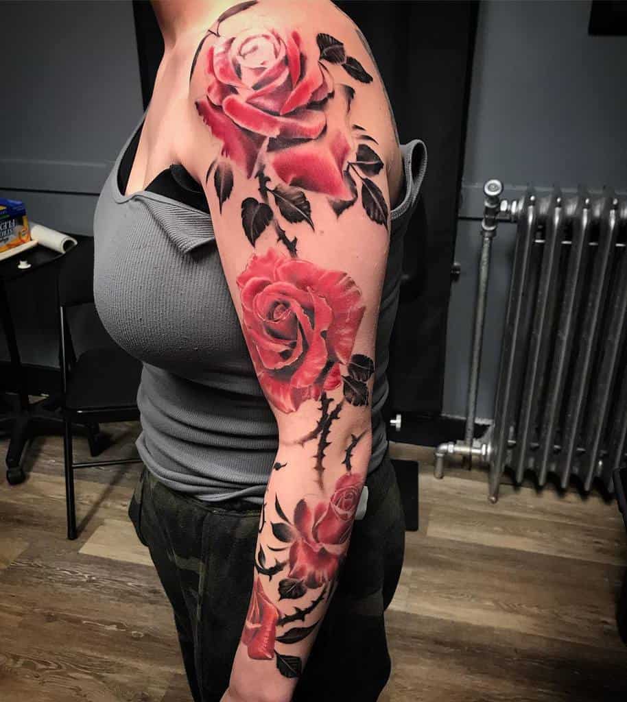 Woman with a colorful rose tattoo sleeve on her arm