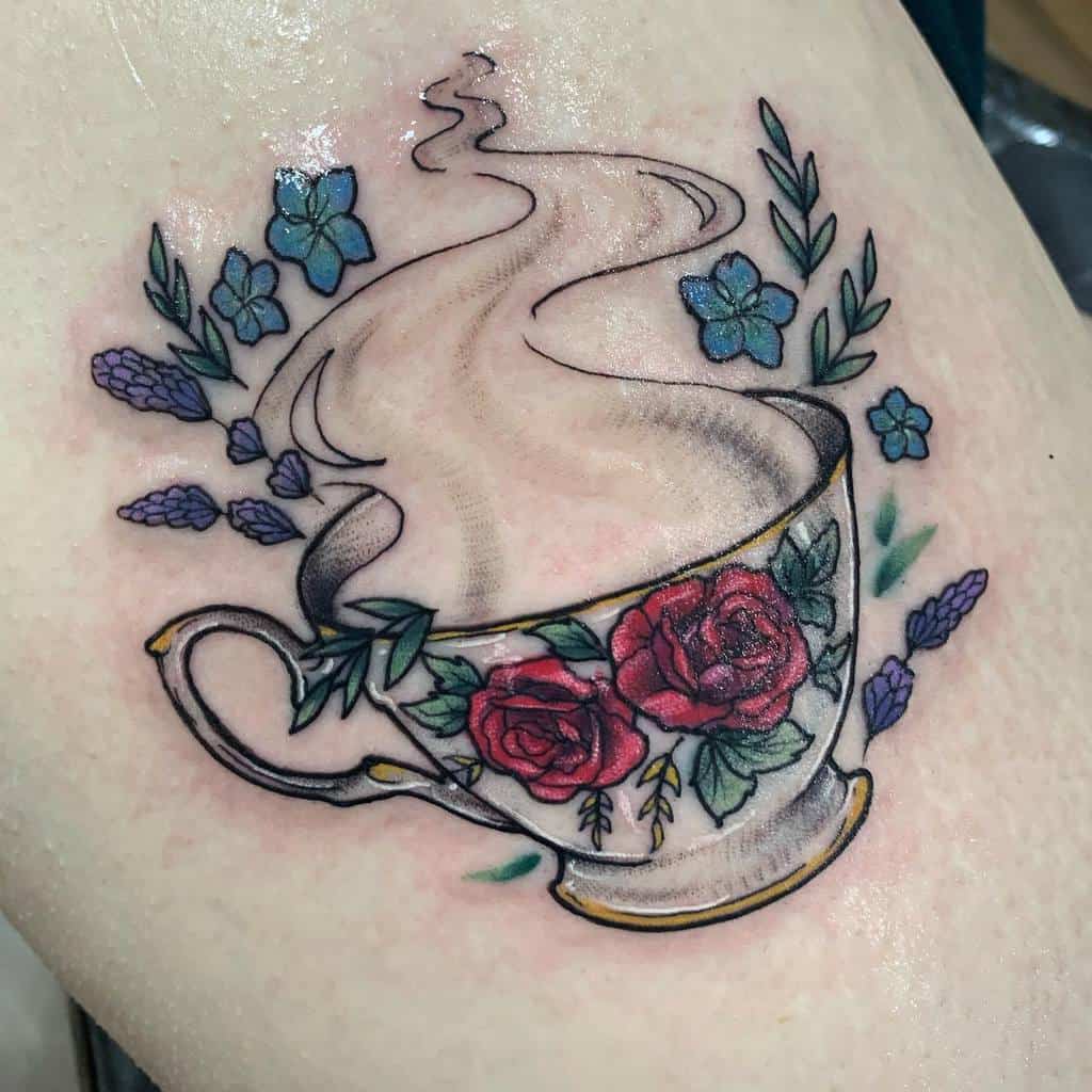 Colorful tattoo of a vintage teacup with red roses, surrounded by blue flowers and lavender, with steam rising in a soft, flowing design