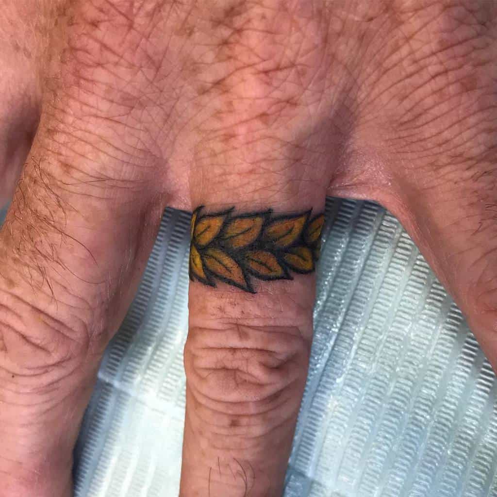 A vibrant ring tattoo featuring a series of yellow and green leaves