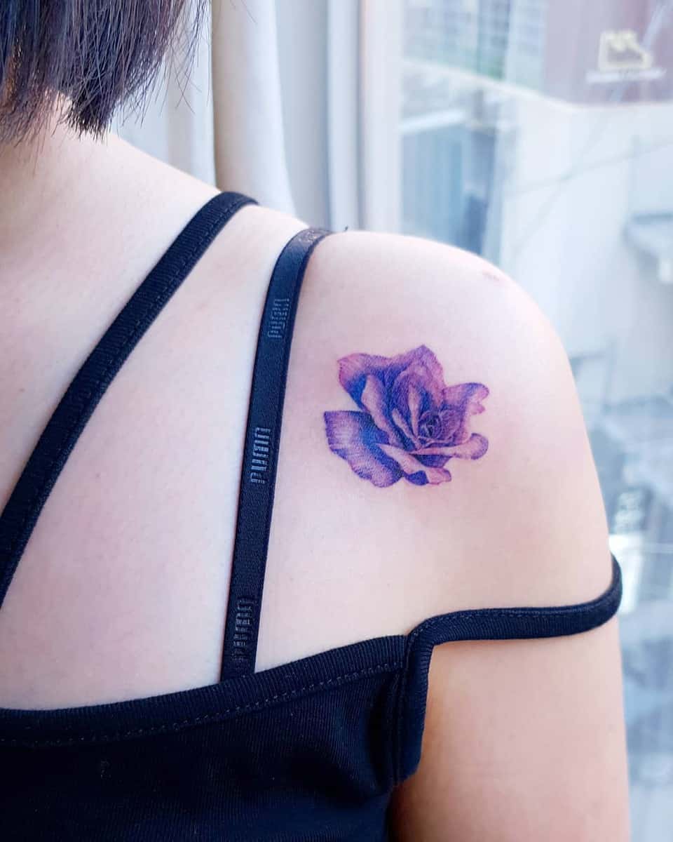 A purple rose tattoo on a shoulder