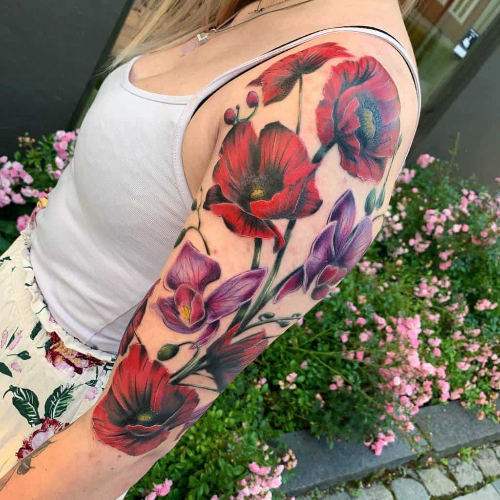 Arm with a colorful tattoo of red poppies and purple orchids