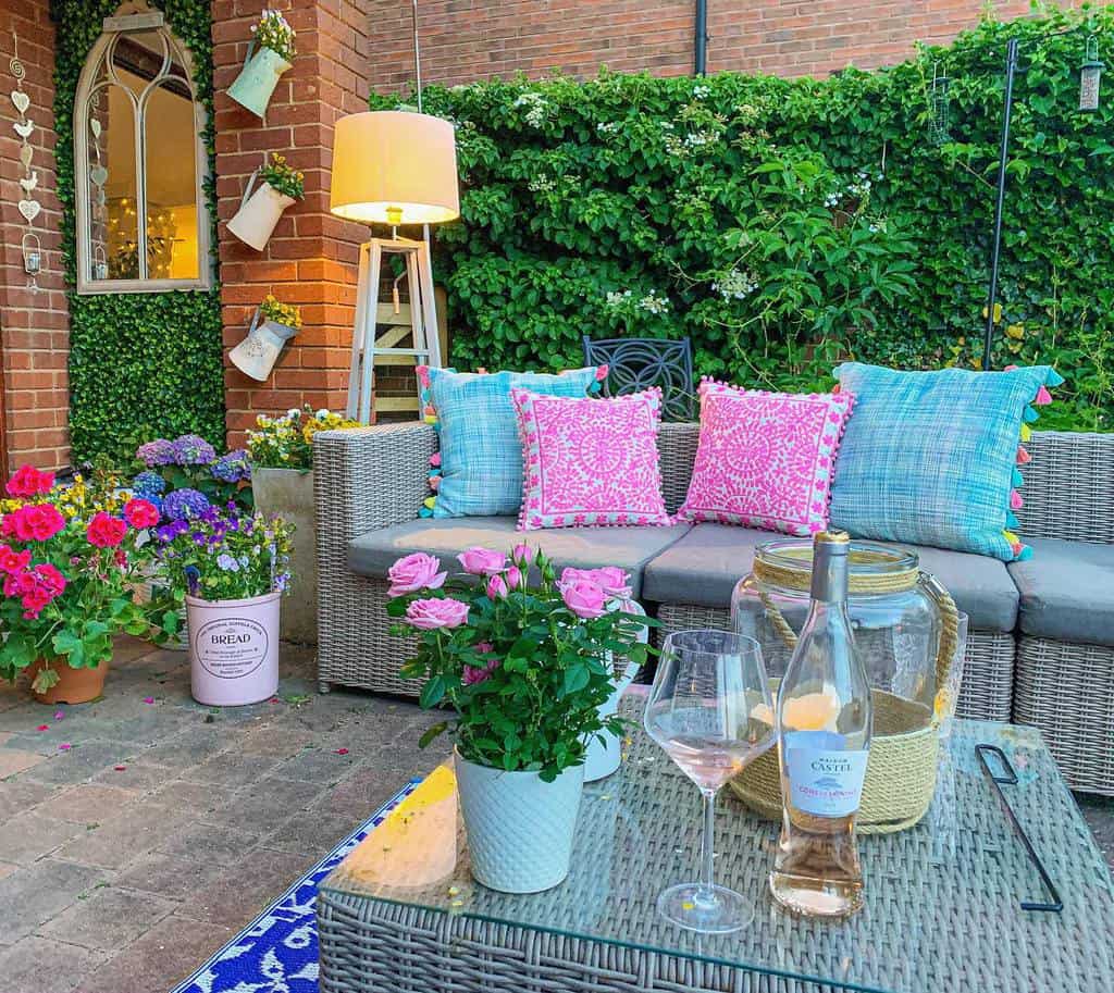 stone paver patio flower garden with wicker furniture 