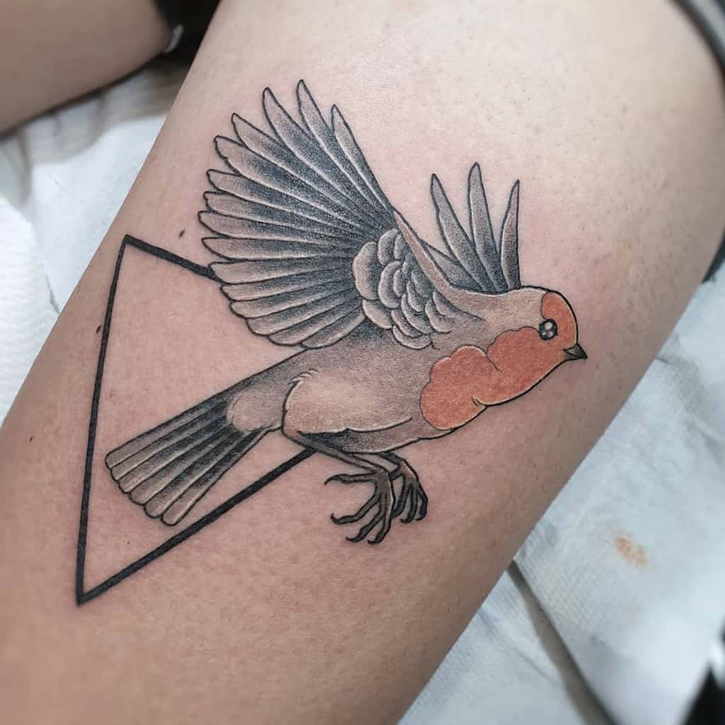 Tattoo of a robin with wings spread, featuring a triangle, the robin has gray and reddish-orange tones