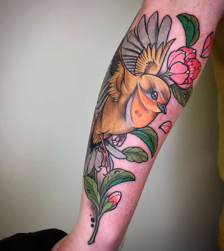 Colorful tattoo of a yellow robin in mid-flight with pink flowers and green leaves