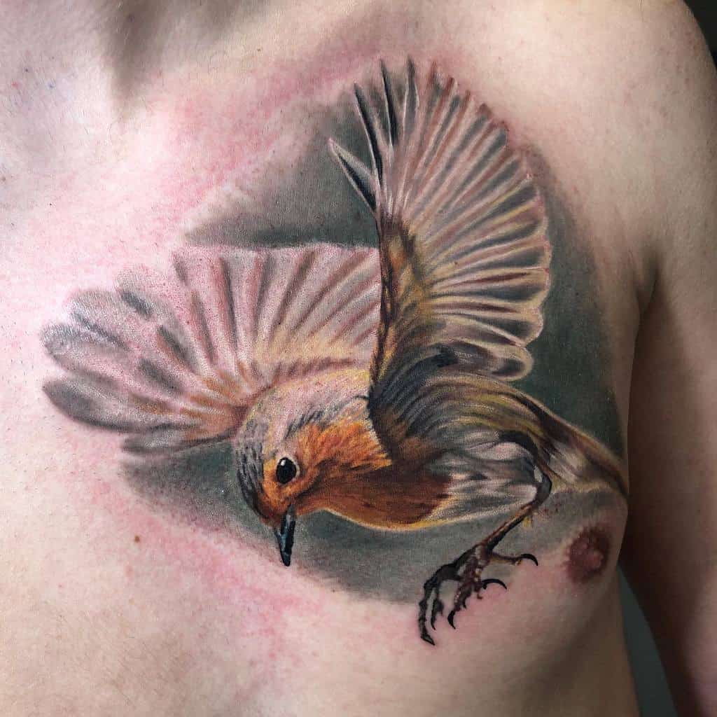 Realistic tattoo of a robin in flight, showing detailed wings and vibrant coloring