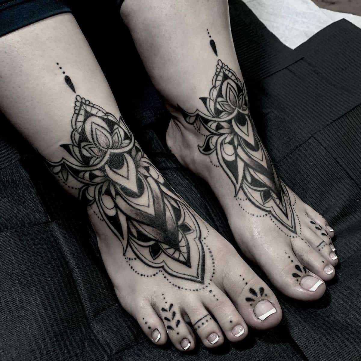 Ornate black henna-style tattoos on feet featuring intricate patterns and designs