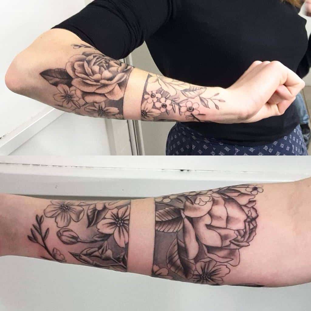 A stunning floral sleeve tattoo graces the forearm, showcasing intricate roses and delicate leaves