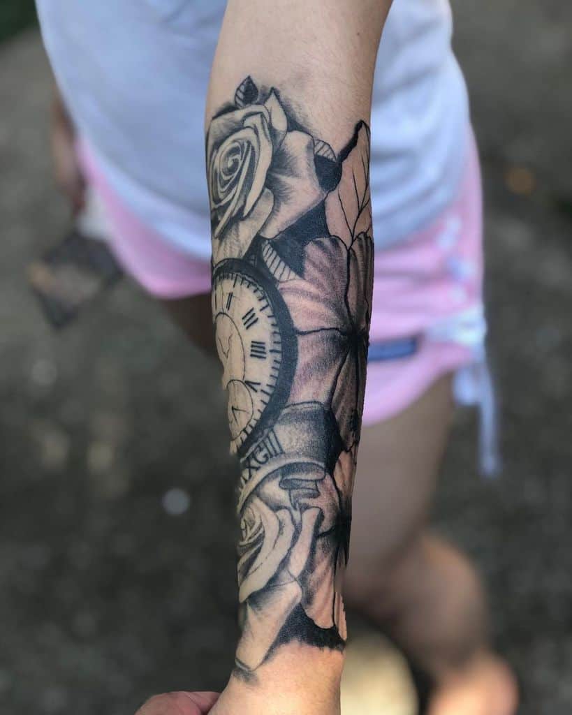 Forearm half sleeve tattoo of a clock with roses and Roman numerals